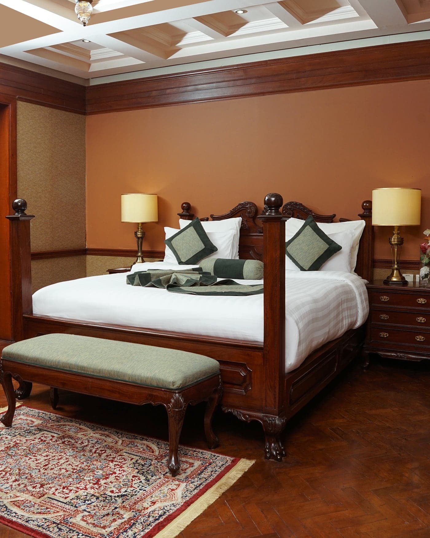 Bedroom with a carved bed beneath a coffered ceiling